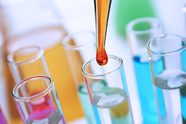 Liquid material being dispensed into test tube with dropper