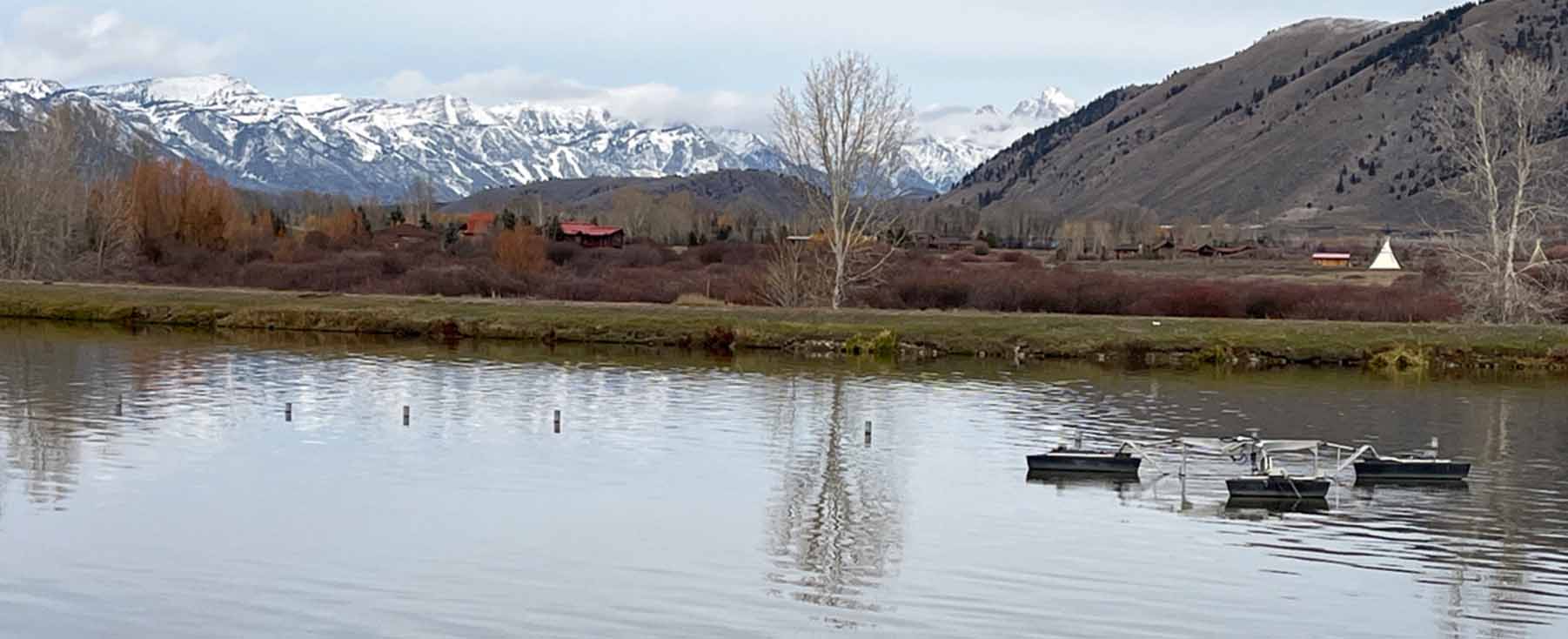 Wastewater treatment lagoon with mountains in the background