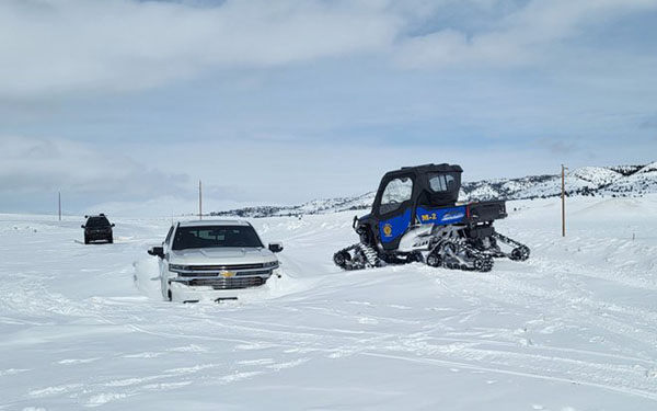 vehicle stuck in a snowbank with a rescue vehicle helping