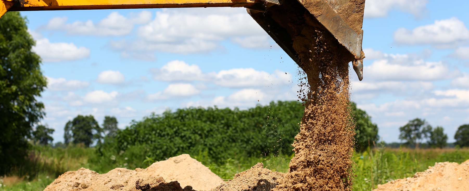 Excavator dropping soil