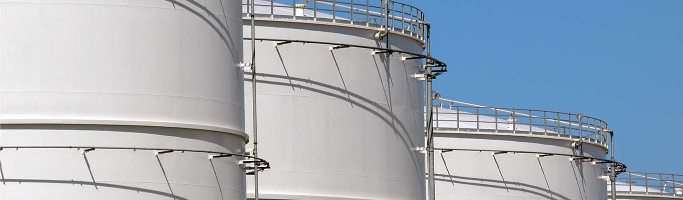 oil and gas storage tanks against clear blue sky