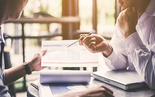 Two people discussing portfolio management documents