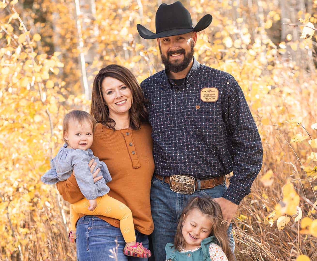 Kristie Twitchell poses with her family in front of fall foliage