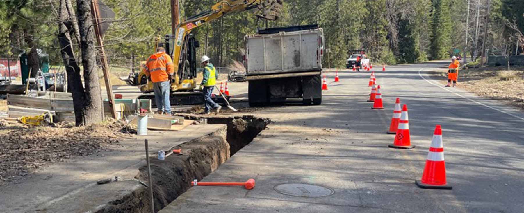 Utility undergrounding - crew digging trench into roadway