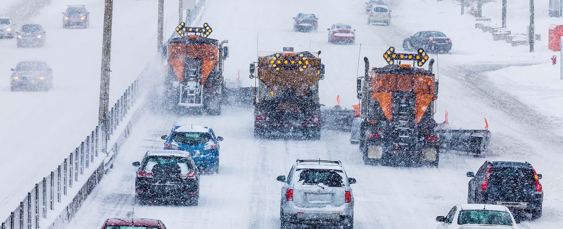 Cars and snow plows on snowy road