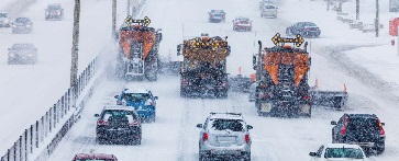 Cars and snow plows on snowy road